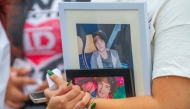 A fan of late British singer Liam Payne hold pictures of him as she pays respects on the esplanade of the Monterrey macroplaza, on October 20, 2024. Photo by Julio Cesar AGUILAR / AFP