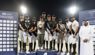 Members of top three finishing teams in  Medium Tour Team category pose on the podium with QEF Assistant Secretary Ali bin Yousef Al Rumaihi.