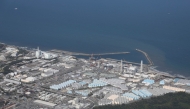 This aerial picture shows storage tanks (bottom) used for storing treated water at TEPCO's crippled Fukushima Daiichi Nuclear Power Plant in Okuma, Fukushima prefecture on August 24, 2023. (Photo by JIJI PRESS / AFP)

