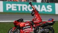 Ducati Lenovo Team's Italian rider Francesco Bagnaia celebrates as he crosses the finish line to win the MotoGP Malaysian Grand Prix at the Sepang International Circuit in Sepang on November 3, 2024. (Photo by Lillian Suwanrumpha / AFP)