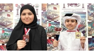 Lian Al Qassabi (L) and Khaled Al Jumaat (R), gold medal holders in the U-10 category of the Arab Chess Championships for age groups 8 to 20 years, in Sousse, Tunisia. 