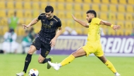 Al Sadd's Boualem Khoukhi (left) vies for the ball with an Al Wasl player.