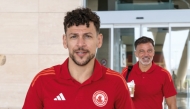 Al Arabi's Youssef Msakni (left) and coach Anthony Hudson arrive in Manama.