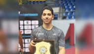 Qatar's Ahmed Korani celebrates with the trophy after winning the boys' U-17 title.