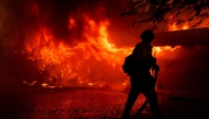 A firefighter tries to control the fire burning down a house as the Mountain Fire scorches acres, the wildfire fueled by strong Santa Ana winds, in Camarillo, California, on November 6, 2024. Photo by ETIENNE LAURENT / AFP