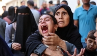 A young Palestinian girl reacts in the courtyard of the al-Shifa hospital in Gaza City after the bodies of victims were transported there, following an Israeli strike that hit a school-turned-shelter in the Al-Shati refugee camp on November 7, 2024. (Photo by Omar Al-Qatta / AFP)