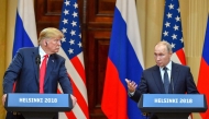 File: US President Donald Trump listens as Russia's President Vladimir Putin speaks during a joint press conference after a meeting at the Presidential Palace in Helsinki, on July 16, 2018. (Photo by Yuri Kadobnov / AFP)