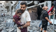 A Palestinian man carries away an injured child from a home that was hit in an Israeli strike on the Jabalia refugee camp on November 7, 2024. (Photo by AFP)