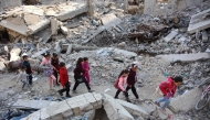 Palestinian girls walk above the rubble of a building destroyed in previous Israeli bombardment, in Gaza City on November 9, 2024. (Photo by Omar AL-QATTAA / AFP)