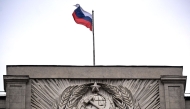 File: A Russian national flag flies atop the Russian State Duma, lower house of Russia's Parliament, as the State Emblem of the Soviet Union is seen on the Soviet era facade, in central Moscow on July 14, 2023.  (Photo by Natalia Kolesnikova / AFP)