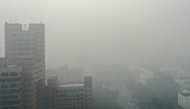 An aerial view shows cars along a road engulfed in smog in New Delhi on November 13, 2024. (Photo by Arun Sankar / AFP)
