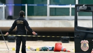 A Brazilian Federal Police stands on November 14, 2024 nearthe body of man carrying explosives who died in a blast as he attempted to attack Brazil's Supreme Court in Brasilia on November 13. (Photo by EVARISTO SA / AFP)