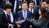 South Korean opposition leader Lee Jae-myung (C) leaves the Seoul Central District Court in Seoul on November 15, 2024, after he was found guilty of making false statements in violation of the Public Official Election Act. (Photo by ANTHONY WALLACE / AFP)