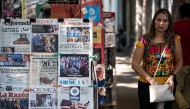 Photo used only for demonstration purposes. A woman walks past a newspaper kiosk displaying front pages with news about the US presidential election in Mexico City on November 6, 2024. Photo by Yuri CORTEZ / AFP.