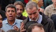 File: King Felipe VI of Spain (right) talks with a resident beside Valencia Regional President Carlos Mazon (left) as angry residents react shouting and throwing mud to the king's visit to Paiporta, in the region of Valencia, eastern Spain, on November 3, 2024, in the aftermath of devastating deadly floods. (Photo by Manaure Quintero / AFP)