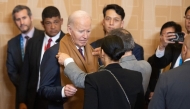 US President Joe Biden has his scarf adjusted prior to a family photo during the Asia-Pacific Economic Cooperation (APEC) Leaders’ Retreat summit in Lima, Peru, November 16, 2024. (Photo by SAUL LOEB / AFP)