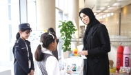 Minister of Education and Higher Education H E Lolwah bint Rashid Al Khater interacts with students displaying their works at an exhibition to mark the day. 