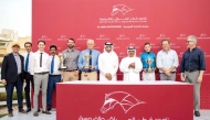 The connections of Dark Trooper celebrate with the trophies after winning the QA Gr3 Barzan Cup at Al Uqda Racecourse. QREC Racing Manager Abdulla Rashid Al Kubaisi crowned the winners. Pictures: Juhaim/QREC
