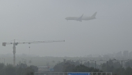 A DHL aircraft prepares to land during a foggy morning at Kempegowda International Airport in Bengaluru on November 22, 2024. (Photo by IDREES MOHAMMED / AFP)