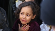 A girl cries as the bodies of victims of an Israeli strike the previous night are brought to at Al-Ahli Arab hospital, also known as the Baptist hospital, in Gaza City on November 22, 2024. (Photo by Omar Al-Qattaa/ AFP)