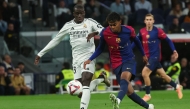 Barcelona's Spanish forward #19 Lamine Yamal (C) is challenged by Real Madrid's German defender #22 Antonio Ruediger during the Spanish league football match between Real Madrid CF and FC Barcelona at the Santiago Bernabeu stadium in Madrid on October 26, 2024. (Photo by Pierre-Philippe MARCOU / AFP)