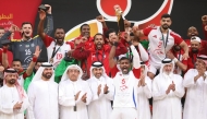 Sharjah SC players and officials celebrate with the trophy after winning the Asian Club Handball Championship yesterday. Qatar Olympic Committee’s First Vice President Mohammed bin Yousef Al Mana, Second Vice President Dr. Thani bin Abdulrahman Al Kuwari, Qatar Handball Federation President Ahmed Al Shaabi and International Handball Federation’s representative for Asia Bader Al Theyab are also present.