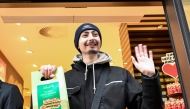 Leon Faehnle holds a Dubai Chocolate bar and smiles after he was the first customer after a ten hour wait who could buy one of 100 Dubai Chocolate bars in a branch of chocolate producer Lindt in Stuttgart, southern Germany, on November 15, 2024.Photo by THOMAS KIENZLE / AFP.