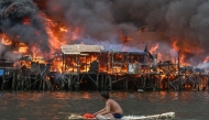  A man watches houses on fire at Tondo in Manila on November 24, 2024. Photo by JAM STA ROSA / AFP