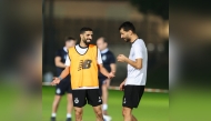 Al Sadd's Hassan Al Haydos (left) with Boualem Khoukhi during a training session.