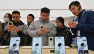 People check Huawei's new Mate 70 mobile phone inside a shop at the Wangfujing shopping area in Beijing on November 26, 2024. (Photo by Adek Berry / AFP)