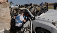 File photo used for representational purposes. United Nations staff members inspect the carcass of a car used by US-based aid group World Central Kitchen, that was hit by an Israeli strike the previous day in Deir al-Balah in the central Gaza Strip on April 2, 2024. Photo by AFP.