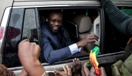 (FILES) Ousmane Sonko(C), President of the opposition party Senegalese Patriots for Work, Ethics and Brotherhood (PASTEF), waves good bye to his supporters at the HLM basic school in Ziguinchor on July 3, 2022. (Photo by MUHAMADOU BITTAYE / AFP)