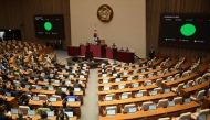 South Korea's National Assembly Speaker Woo Won-shik (Centre top) passes a resolution demanding the immediate lifting of martial law at the National Assembly in Seoul on December 4, 2024, after South Korea President Yoon Suk Yeol declared martial law. (Photo by Yonhap / AFP) 