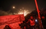 People run for cover as an explosion from an Israeli strike occurs near a makeshift camp for displaced Palestinians, in Mawasi Khan Yunis in the southern Gaza Strip on December 4, 2024. (Photo by Bashar Taleb / AFP)