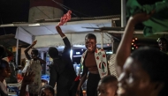 Supporters of former Ghana president and presidential candidate of the National Democratic Congress (NDC) party John Mahama cheer as they wait for results in front of a polling station in Accra on December 7, 2024 during the Ghana presidential and parliamentary elections. (Photo by OLYMPIA DE MAISMONT / AFP)
