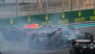 Red Bull Racing's Dutch driver Max Verstappen (left) drives on after a collision with McLaren's Australian driver Oscar Piastri during the Abu Dhabi Formula One Grand Prix at the Yas Marina Circuit in Abu Dhabi on December 8, 2024. (Photo by Andrej Isakovic / AFP)