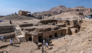 Visitors walk around a dig showcasing the tomb of an overseer of the palace of Queen Teti Sheri, during a media event to announce new discoveries by an Egyptian archaeological mission in Deir El-Bahari on the Nile's west bank in Luxor on January 8, 2025. (Photo by Khaled DESOUKI / AFP)