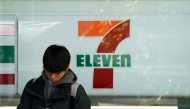 A man stands in front of a 7-Eleven convenience store along a street in central Tokyo on January 9, 2025. (Photo by Kazuhiro NOGI / AFP)