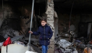 The daughter of a man killed during an Israeli air strike the previous day, checks the destruction at the site of the attack, in Jenin's refugee camp in the occupied West Bank, on January 16, 2025. (Photo by Zain JAAFAR / AFP)
