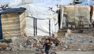 A girl rides a bicycle outside tents at a camp for people displaced by conflict in Bureij in the central Gaza Strip on January 17, 2025. (Photo by Eyad Baba / AFP)