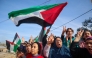 Displaced Palestinians wave national flags as they return to Rafah, in the southern Gaza Strip, on January 19, 2025. (Photo by Eyad Baba / AFP)