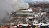 Fire engines are seen on a road as smoke rises from the roof of the National Hangeul Museum in Seoul on February 1, 2025. (Photo by YONHAP / AFP) 