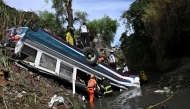 Firefighters work at the scene of an accident in which a bus fell down a ravine in Guatemala City on February 10, 2025. Photo by Johan ORDONEZ / AFP