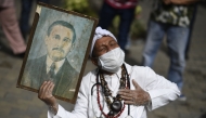 File: A woman holds a portrait of Venezuelan doctor Jose Gregorio Hernandez, also called 