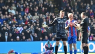 Crystal Palace's French striker #14 Jean-Philippe Mateta (L) lies injured after a dangerous challenge from Millwall's English goalkeeper #13 Liam Roberts (3R) in south London on March 1, 2025. (Photo by Glyn Kirk / AFP) 