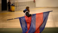 A staff member takes away the FC Barcelona's flag following the decision to cancel the Spanish league football match between FC Barcelona and CA Osasuna at Estadi Olimpic Lluis Companys in Barcelona on March 8, 2025. (Photo by Josep LAGO / AFP)
