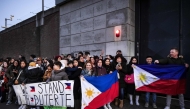 Protesters holding Filipino flags and a banner in support of former Philippine President Rodrigo Duterte gather outside the The Hague Penitentiary Institution prison, which houses the International Criminal Court's (ICC) detention unit, on March 12, 2025. (Photo by Ramon van Flymen / ANP / AFP)
