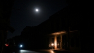 Cubans chat on the entrance of a house during a general blackout in Havana on March 14, 2025. (Photo by Yamil Lage / AFP)