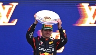 Second-placed Red Bull Racing's Dutch driver Max Verstappen celebrates on the podium with his trophy at the end of the Australian Formula One Grand Prix at Albert Park Circuit in Melbourne on March 16, 2025. (Photo by William West / AFP) 