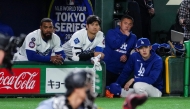 Los Angeles Dodgers' Shohei Ohtani (C), Teoscar Hernandez (L) and Roki Sasaki (R) watch from the dugout during the exhibition baseball game between the Los Angeles Dodgers and Hanshin Tigers at the Tokyo Dome in Tokyo on March 16, 2025. (Photo by Yuichi Yamazaki / AFP) 